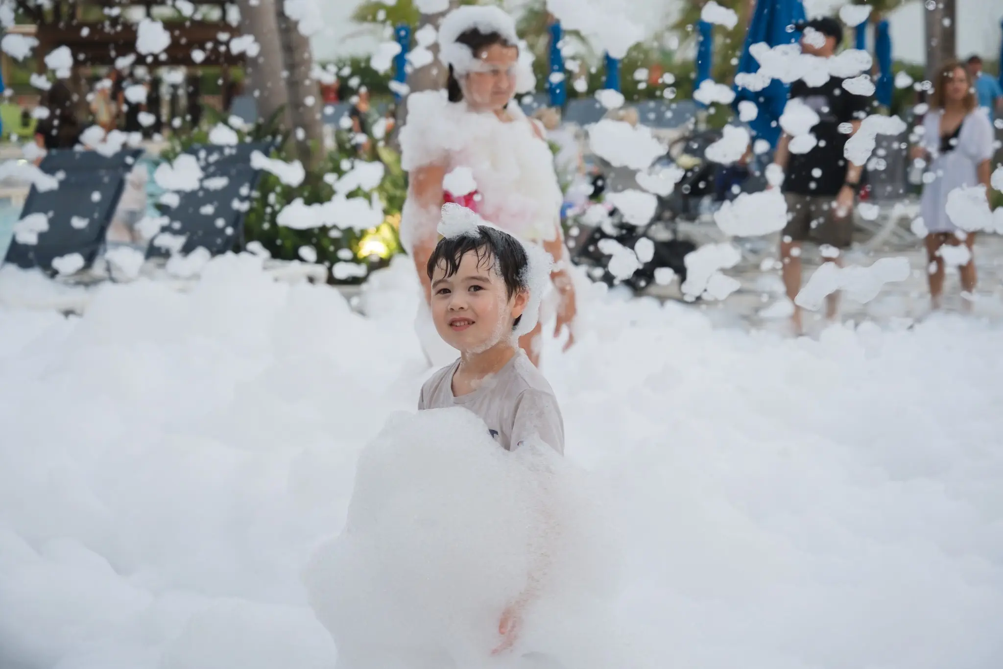 Child carrying a big pile of foam at a Central Florida foam party