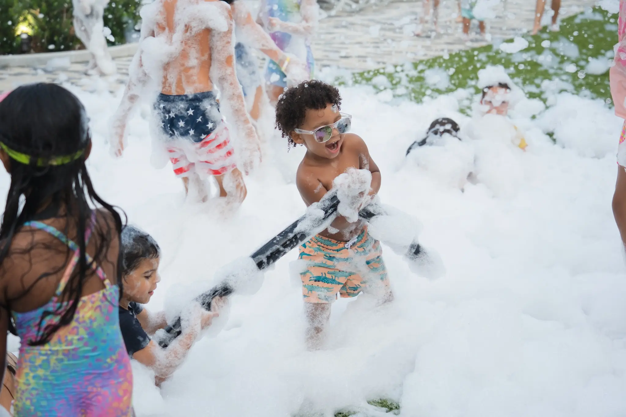Kids wearing sunglasses playing in a FoamHype foam party